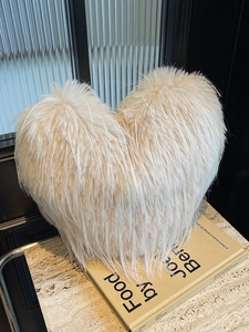 Sac fourre-tout en forme de cœur en fausse fourrure crème sur une surface en marbre