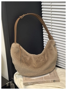 Detail of soft brown faux fur texture and adjustable leather strap on a hobo shoulder bag