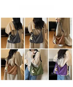 Détail de sacs bandoulière en toile à carreaux en quatre couleurs avec breloque lune
