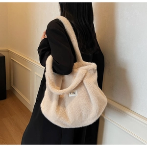Gros plan sur un grand sac cabas en peluche crème avec perle et fausse fourrure