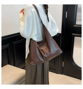 Brown leather shoulder bag on a model in a modern interior setting for daily use