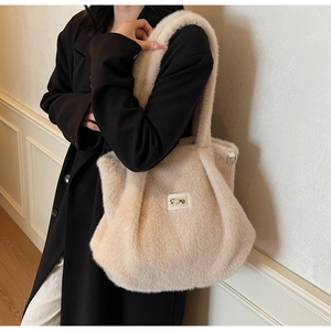 Détail du sac cabas en peluche douce avec étiquette Story et décoration en perle