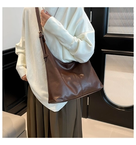 Detail of vintage dark brown PU leather hobo bag showing texture and adjustable wide strap
