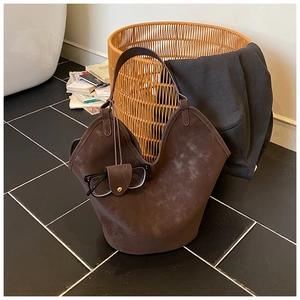 Detailed view of dark brown suede tote bag with matching leather glasses case attachment