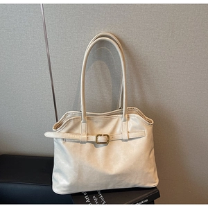 Détail du sac cabas crème avec ouverture plissée et accents de boucles en métal doré