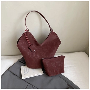 Detail view of burgundy faux suede tote bag set with wide shoulder strap and matching pouch
