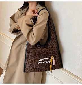 Dettaglio della grande borsa tote leopardata con corda gialla e nappa rosa sul modello
