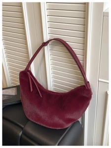 Detail of burgundy faux fur hobo bag showing soft texture and adjustable leather strap