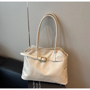 Détail d'un sac cabas en cuir PU crème avec boucle dorée et plis élégants