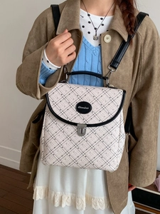 Vintage checkered backpack in cream and black with elegant metal clasp and top handle