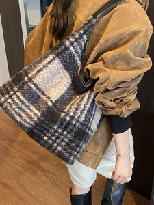 Grand sac cabas en laine à carreaux noir et blanc porté par un mannequin pour l'automne-hiver