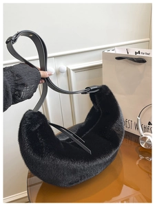 Detail of black faux fur hobo bag showing its fluffy texture and adjustable leather strap