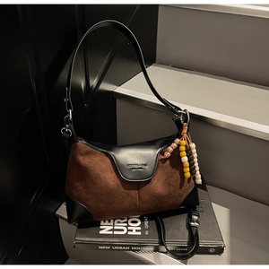 Detail of vintage suede hobo bag with bohemian beads on a dark urban setting
