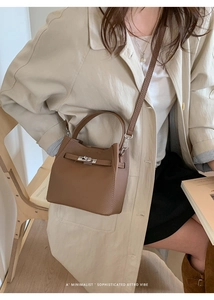 Detail shot of a dark brown pebble leather bucket bag with silver twist lock and strap
