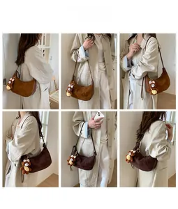 Detail view of suede hobo bag with a cute plush bear charm in caramel and dark brown