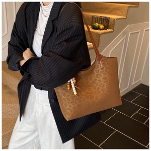 Détail du sac cabas vintage en cuir ciré avec imprimé léopard et pompon en perles