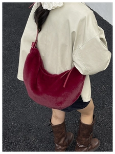 Close-up of fluffy red faux fur crescent bag showing soft texture and shoulder strap