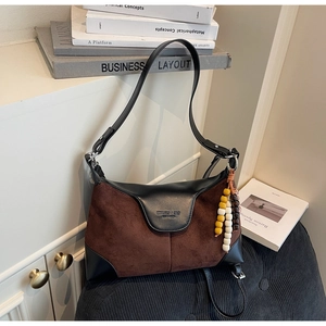 Detail of a color-block suede crossbody bag with vintage wooden beads and logo embossing