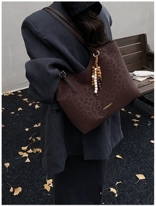 Sac fourre-tout marron à imprimé léopard avec pendentif à perles porté à l'épaule