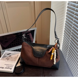 Detail of coffee suede and black leather dumpling bag with decorative colorful beads