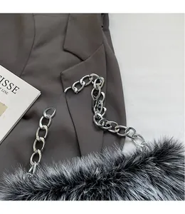 Gros plan d'un sac à main en peluche avec une grosse bandoulière en chaîne argentée