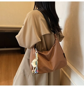 Détail du sac hobo montrant le motif à carreaux marron et le charme de lune