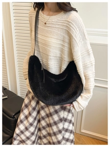 Detail of soft black faux fur dumpling bag with slim leather strap for autumn fashion