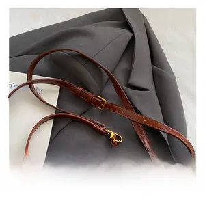 Détail de la bandoulière réglable en cuir marron avec boucle dorée pour sac à main