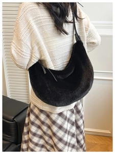 Detail of black faux fur hobo bag with sleek leather strap and fluffy texture