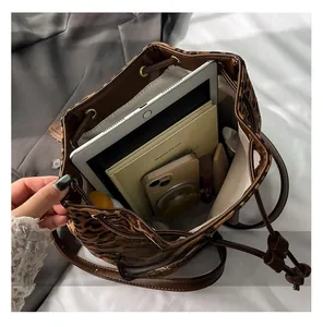 Spacious interior of leopard print bucket bag showing tablet and notebook storage