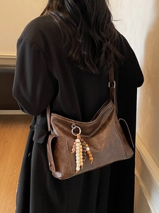 Retro dark brown large capacity crossbody bag with wood bead tassel on a model
