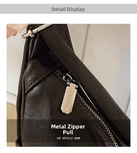 Close-up of golden hexagonal metal zipper pull on textured brown leather bag