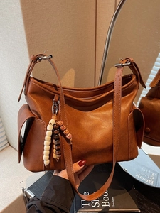 Brown vintage leather crossbody bucket bag with adjustable strap and decorative wood beads