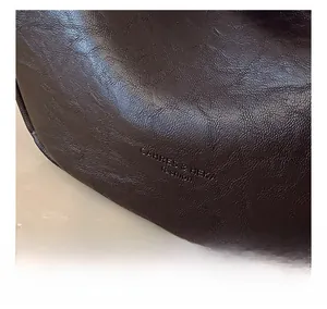 Close-up of dark brown lychee pattern leather with delicate grain and oily luster