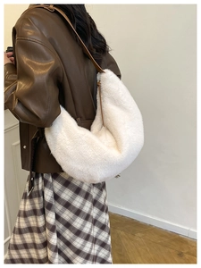 Detailed view of a white fluffy crescent bag with a brown leather strap on a model