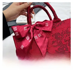 Détail du sac de mariée rouge avec jacquard floral et un nœud en soie aux caractères Xi