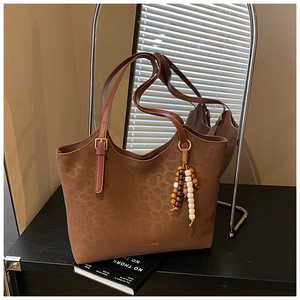 Gros plan d'un cabas léopard marron avec pompon en perles et logo Fashion & Bags