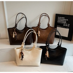 Detailed view of tote bags in four colors with wood bead tassels and knot handle detail