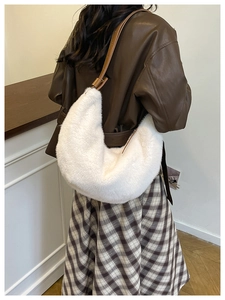 White faux fur crescent shoulder bag with brown leather strap shown on model's shoulder