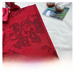 Vue détaillée du sac cabas de mariée rouge avec tissu jacquard floral et un grand nœud