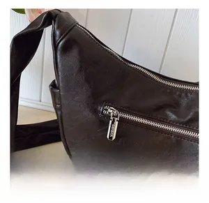 Detail showing the back zipper pocket and high-quality leather texture of the bag