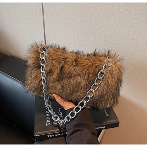 Détail d'un sac à main en fausse fourrure marron avec une grosse chaîne en métal argenté