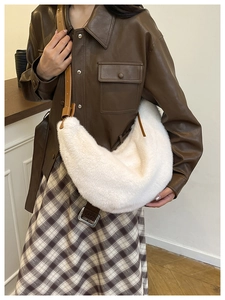 White faux fur half-moon bag with dark brown leather strap detail and soft plush texture