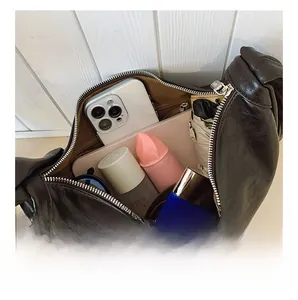 Macro view showing large capacity interior of dark brown hobo bag with daily essentials