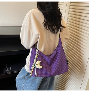 Détail du sac hobo à carreaux violets avec pendentif lune et cordon décoratif