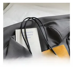 Dettaglio della borsa tote in pelle opaca giallo zenzero con ciondolo di perline vintage