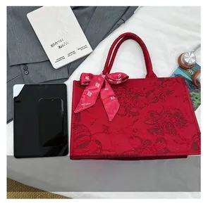 Détail du sac de mariée en jacquard rouge avec ruban logo et motif traditionnel 囍