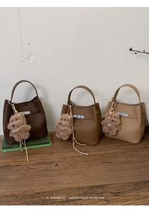 Detailed comparison of three lychee grain leather bucket bags with plush dog charms
