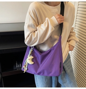 Détail du sac en toile à carreaux violets avec un joli porte-clé en peluche demi-lune