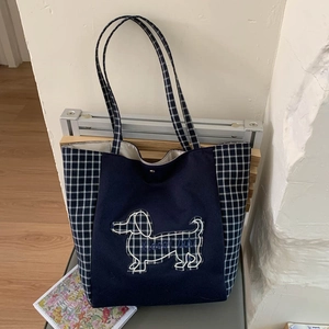 Vue détaillée du cabas en toile bleu foncé avec bordure à carreaux et broderie teckel